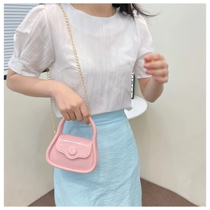 Close-up of pink mini jelly bag with gold chain strap shown on a model