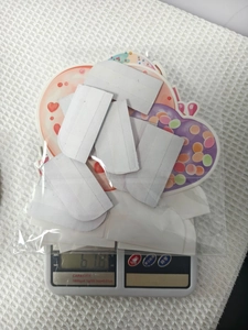 Detailansicht des 6,18g Gewichts der Donut-Party-Papierdeko auf einer Digitalwaage