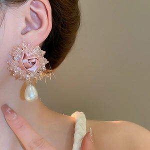 Detailed shot of pink fabric rose earrings with crystal beads and pearl drop pendant
