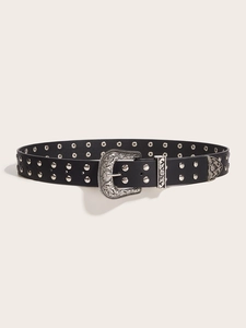 Close-up of vintage Western belt featuring intricate silver buckle and metal studs