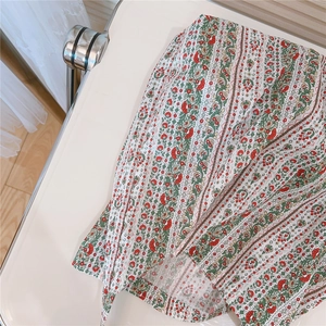 Détail d'un sac en coton doux avec des motifs floraux ethniques rouges et verts