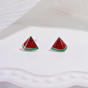 Détail macro de boucles d'oreilles pastèque avec finition émaillée rouge et verte vive