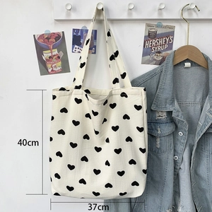 Detailed view of canvas tote bag showing black heart print and 40x37cm dimensions