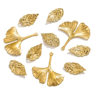 Macro shot of golden ginkgo leaf pendants and realistic vein charms for DIY jewelry making