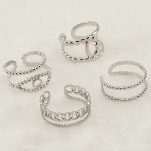 Detailed stack of adjustable silver stainless steel rings on a white plush background