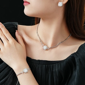 Gros plan d'un mannequin portant un ensemble de bijoux argentés avec collier et boucles