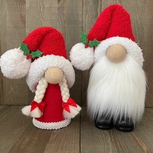 Close-up of handmade Christmas gnomes with knitted hats and white faux fur beards
