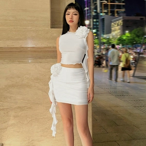 Detail of white two-piece set featuring 3D floral applique and ruffle mini skirt for women