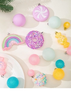 Détail d'ornements de Noël macaron avec beignets, arcs-en-ciel et boules pailletées colorées