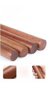 Macro detail of polished African ebony wood rolling pin with smooth rounded edges