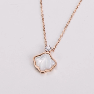 Detail of rose gold seashell pendant with white mother of pearl inlay and zircon