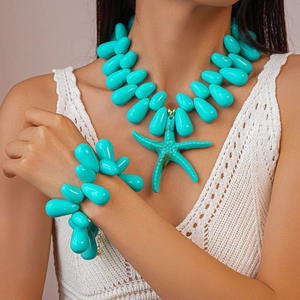 Detail of teal resin beads and a textured starfish pendant on a holiday necklace set