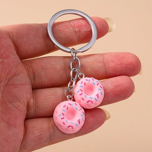 Close-up of pink realistic donut keychains with colorful sprinkles and silver metal ring