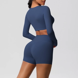 Detail of high waist fit and compression fabric on navy blue yoga shorts and crop top set