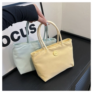 Détail de sacs bandoulière en nylon vert clair et jaune avec logo m gaufré