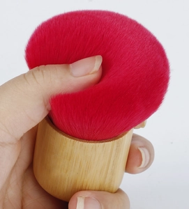 Macro view of soft red synthetic bristles and bamboo handle of the powder brush