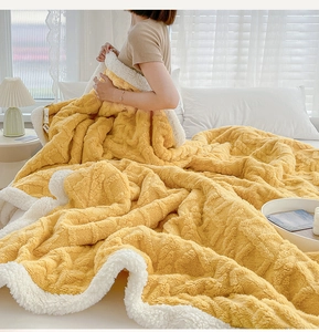 Detail of yellow tufted fleece blanket showing thick reversible plush texture and stitching