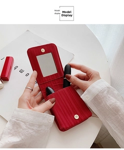 Detail of red textured fabric lipstick case with built-in mirror and magnetic gold clasp