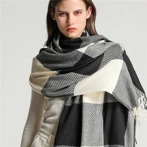 Detail of soft black, white and grey plaid scarf with decorative fringe tassel edges