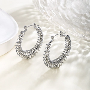 Polished silver chain hoop earrings with spiral design on textured glass backdrop