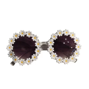 Detail of round frame kids sunglasses with white daisy floral design and gradient lenses