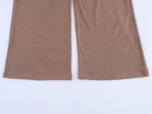 Vista detallada de los pantalones de punto marrones con pernera ancha y dobladillo acampanado