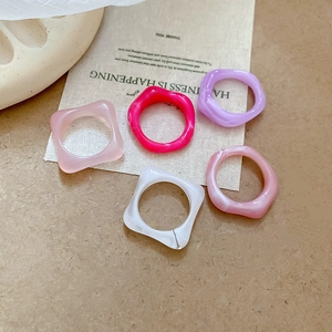 Close-up of five acrylic resin rings featuring colorful marble texture and jelly gloss