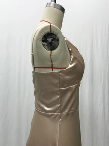 Détail de la robe de soirée en satin champagne montrant la coupe ajustée et la texture