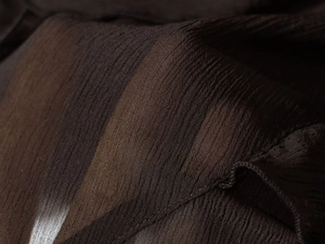 Vue macro d'un tissu marron foncé avec texture plissée raffinée et drapé fluide