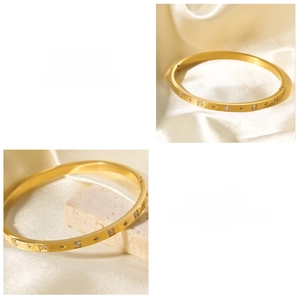 Dettaglio di un bracciale rigido placcato oro 18k con zirconi e chiusura a cerniera sicura