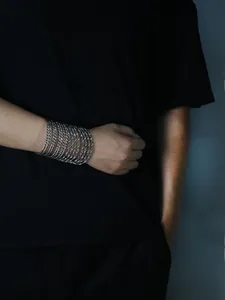 Detail of silver multi-layered rope chain bracelet with industrial punk style texture