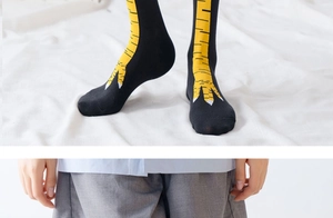 Detail showing high-stretch black long socks with funny yellow chicken feet pattern