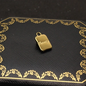 Detailed macro view of a gold-plated butterfly pendant with Beauty cursive engraving