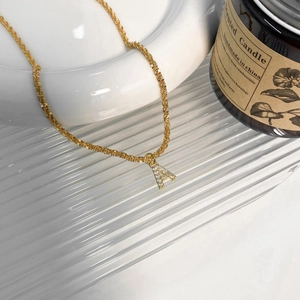 Vue détaillée du collier doré et pendentif lettre A serti de zircons étincelants