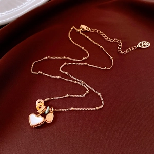 Detail of 18k gold heart pendant with enamel on deep red silk fabric background