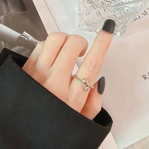 Elegant silver open ring with cubic zirconia hearts shown on a hand with black nails