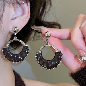 Detailed view of vintage silver hoops with textured dark leather-like wave elements