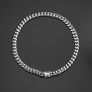 Silver polished stainless steel Cuban link necklace with secure box clasp on black background