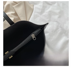 Close-up of premium silver metal zipper and hardware on black leather tote bag