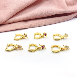 Detail of gold plated hoop earrings featuring colorful heart-shaped zircon charms