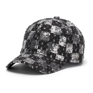 Detail of sequins on checkered tweed baseball cap with silver metallic finish texture