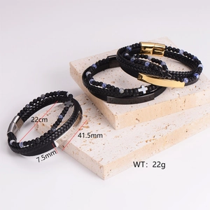 Stackable punk braided leather bracelet set with beads and cross charm on stone tray