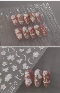 5D embossed nail stickers featuring white floral patterns, pearls and gold foil accents
