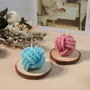 Detalle de velas de bola de lana azules y rosas en una base de madera natural