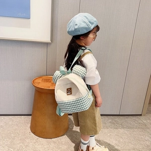 Kids mini backpack with light green plaid pattern and bear ear details on child model