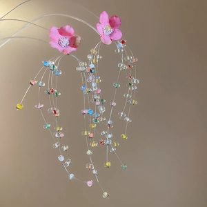 Detail of flower earrings with colorful crystal beads and delicate long fringe tassels
