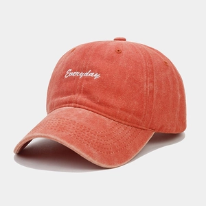 Close-up of vintage washed orange baseball cap with white Everyday embroidery detail