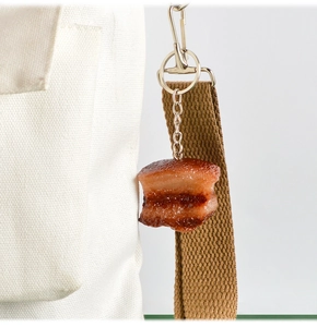 Portachiavi realistico a forma di carne di maiale brasata su una borsa di tela