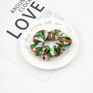 Detail of Christmas tree pattern fabric scrunchie on a white plate over a magazine