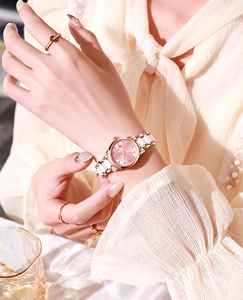 Détail du bracelet en or rose et céramique blanche avec index en cristal sur cadran rose
